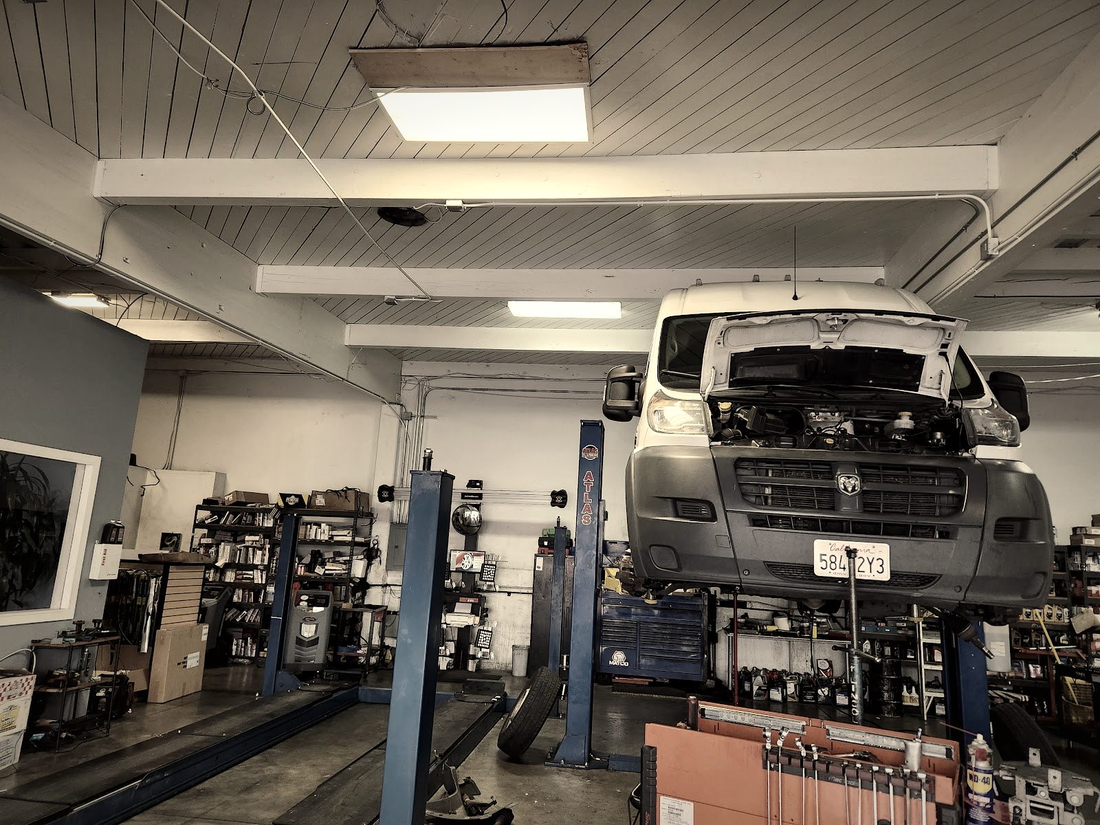 A work van on the lift at Zip In Auto
